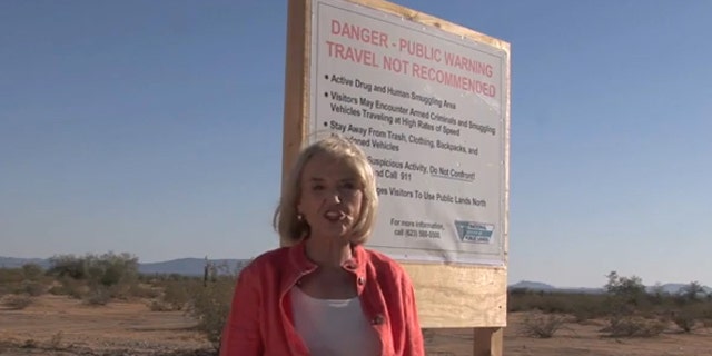 Arizona Gov. Jan Brewer is shown next to a warning sign in the desert in a campaign ad. (Governor Jan Brewer 2010)