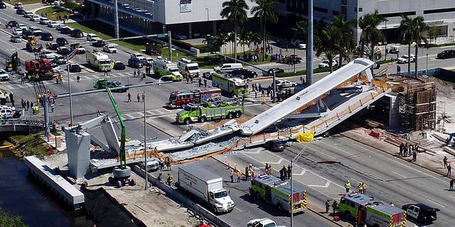 Emergency personnel respond after a brand-new pedestrian bridge collapsed onto a highway at Florida International University in Miami on Thursday, March 15, 2018. The pedestrian bridge collapsed onto the highway crushing multiple vehicles and killing several people. (Pedro Portal/Miami Herald via AP)