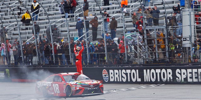Kyle Busch celebrates after winning during a NASCAR Cup Series auto race, Monday, April 16, 2018 in Bristol, Tenn. (AP Photo/Wade Payne)