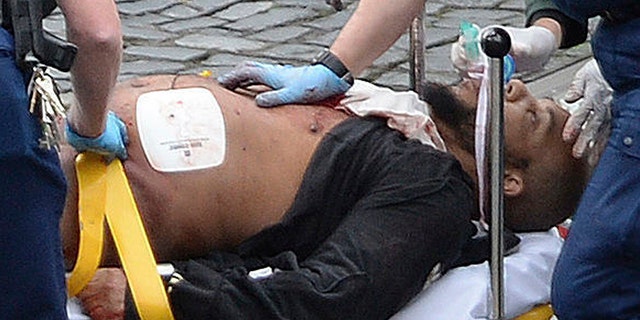 FILE- In this March 22, 2017 file photo, the attacker Khalid Masood is treated by emergency services outside the Houses of Parliament London. British Police named on Thursday March 23, 2017, Khalid Masood as The Houses of Parliament attacker. (Stefan Rousseau/PA via AP, File).