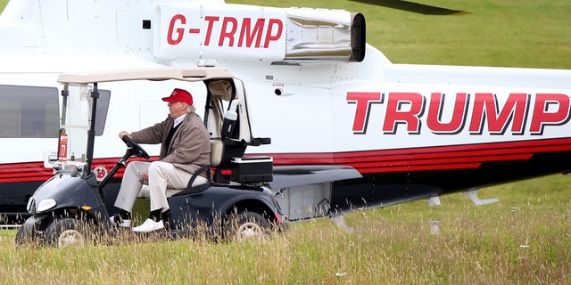 July 31, 2015: US presidential contender Donald Trump drives his golf buggy past his helicopter during the second day of the Women's British Open golf championship on his Turnberry golf course in Turnberry, Scotland.