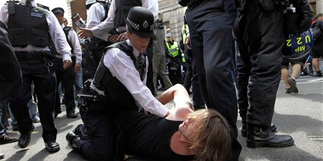 June 30: A British police officer holds down a protester in Whitehall, London as thousands of public sector workers and teachers protest in central London in a one day strike over pension and government cuts. British teachers and public service workers swapped classrooms and offices for picket lines as hundreds of thousands walked off the job to protest pension cuts.