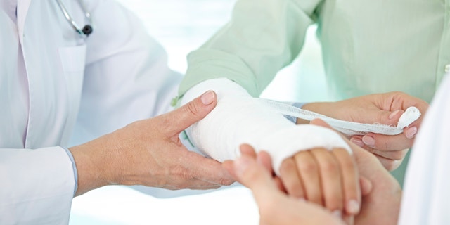 Doctor and nurse bandaging patients broken arm