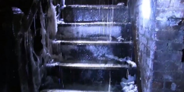 Icicles and water from melting snow cover a stairwell inside the building.