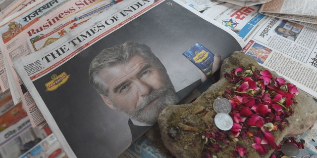 A newspaper with a front page advertisment of former 007 star Pierce Brosnan endorsing an Indian mouth freshener, is seen on the streets of New Delhi on October 7, 2016.
Former 007 star Pierce Brosnan sparked ridicule on social media October 7, 2016 by starring in a new James Bond-style spoof commercial for an Indian mouth freshener that left fans shaken and stirred. / AFP / DOMINIQUE FAGET (Photo credit should read DOMINIQUE FAGET/AFP/Getty Images)
