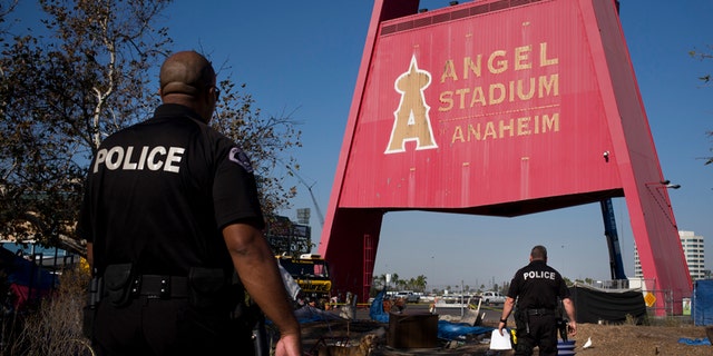 Officers are seen walking through the homeless camp outside Angel Stadium in late 2017, before the mass move-out.