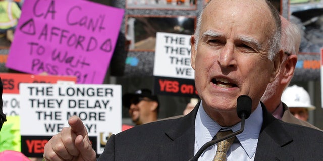In this April 5, 2017, photo, California Gov. Jerry Brown urges lawmakers to approve the plan for a $5 billion-a-year tax and fee road repair measure during a rally in Sacramento, Calif.