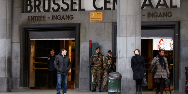 Commuters walk past soldiers on duty at Brussels Central Station as they return to work after the easter holidays in Brussels, Tuesday, March, 29, 2016. The mayor of Brussels, holding special meetings in Paris after deadly attacks on his city, says the European Union's capital can never go back to "normal" again. Yvan Mayeur met with Paris Mayor Anne Hidalgo in the French capital's neo-Renaissance city hall Tuesday for discussions on how Paris reacted to the November attacks.(AP Photo/Alastair Grant)