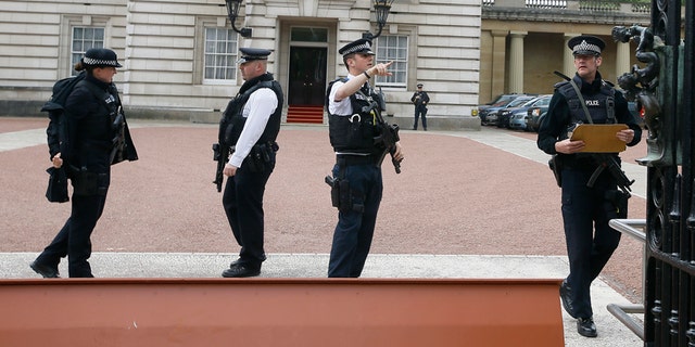 May 19, 2016: Armed police officers work at the main gate of Buckingham Palace in London.