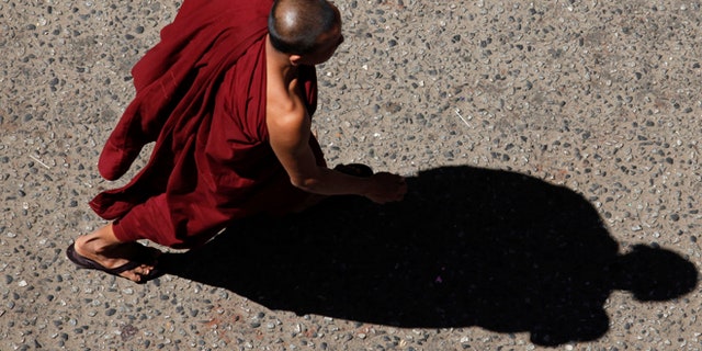 A Buddhist monk was charged after he allegedly beat a young boy for "playful" behavior during a prayer ceremony.
