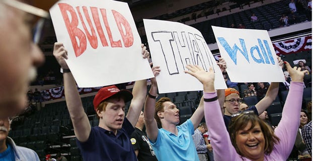 People hold signs that read, " Build that Wall", as they wait for Republican presidential candidate Donald Trump on Feb. 12, 2016 in Tampa, Fla. (Joe Raedle/Getty Images)