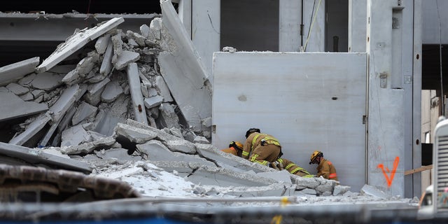 DORAL, FL - OCTOBER 10:  Miami-Dade Rescue workers prepare to pull a body out of the rubble of a four-story parking garage that was under construction and collapsed at the Miami Dade College?s West Campus on October 10, 2012 in Doral, Florida.  Early reports indicate that one person was killed in the collapse, at least seven people injured and one person may still be trapped in the rubble.  (Photo by Joe Raedle/Getty Images)
