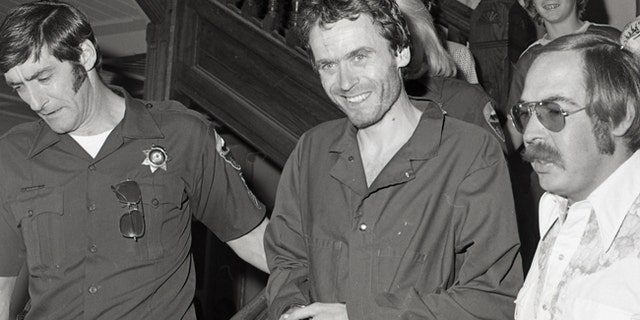 In this 1977 photo serial killer Ted Bundy, center, is escorted out of court in Pitkin County, Colo. The Glenwood Springs Post-Independent discovered the 40-year-old photo of Bundy, along with others, that had been locked in an old safe in the newsroom, which a local locksmith volunteered to open. The photos show Bundy in custody in 1977, the year he escaped from local law enforcement twice while awaiting a murder trial. (Glenwood Springs Post Independent via AP)