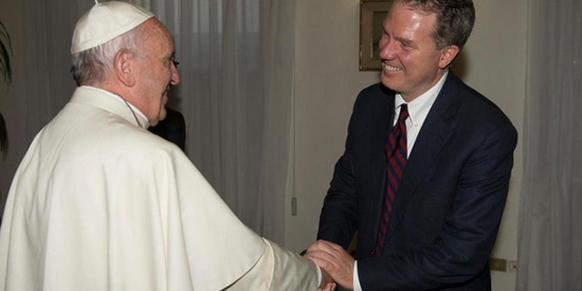 Pope Francis shakes hands with Greg Burke at the Vatican on Monday. (L'Osservatore Romano/Pool photo via AP)