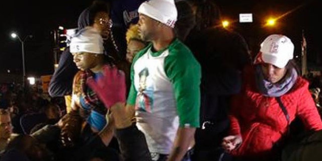 Louis Head, shown here in the green and white shirt, was videotaped shouting "Burn this bitch down!" after a grand jury declined to indict Ferguson Police Officer Darren Wilson in the shooting of Head's stepson, Michael Brown. (AP)