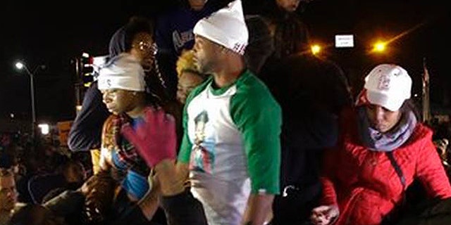 Louis Head, shown here in the green and white shirt, was videotaped shouting "Burn this bitch down!" after a grand jury declined to indict Ferguson Police Officer Darren Wilson in the shooting of Head's stepson, Michael Brown. (AP)