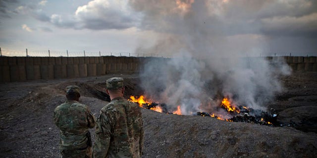 Feb. 4, 2013: U.S. Army soldiers watch garbage burn in a burn pit at Forward Operating Base Azzizulah in Maiwand District. Soldiers at FOB Sharana had to use a similar burn pit because incinerators were not completed.