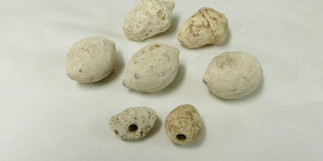 Some of the Roman sling bullets found at the Burnswark Hill battle site in Scotland. The two smallest bullets, shown at the bottom of this image, are drilled with a hole that makes them whistle in flight.