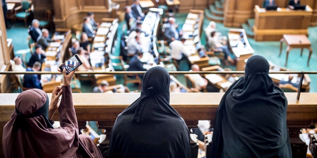 Women wearing the islamic veil niqab sit in the audience seats of the Danish Parliament, at Christiansborg Castle, in Copenhagen, Denmark, Thursday May 31. 2018.