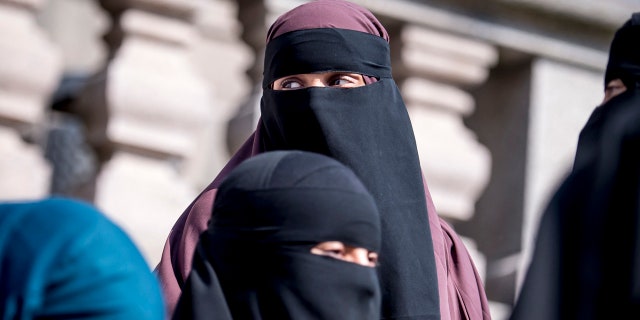 Women wearing the islamic veil niqab stand outside the Danish Parliament, at Christiansborg Castle, in Copenhagen, Denmark, Thursday May 31. 2018.