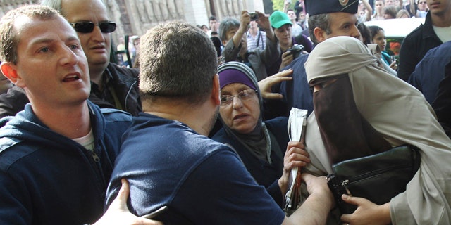 April 11: An unidentified veiled woman, right, is taken away by plain clothed police officers, left and second left, as she is accompanied by two friends, center left and right, in Paris. France's new ban on Islamic face veils was met with a burst of defiance Monday, as several women appeared veiled in front of Paris' Notre Dame Cathedral and two were detained for taking part in an unauthorized protest. France on Monday became the world's first country to ban the veils anywhere in public. (AP)