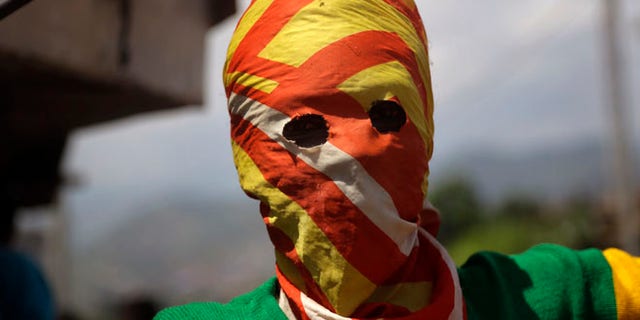 May 21, 2015: A masked Protester waits for police during clashes in the Nyakabyga neighborhood of Bujumbura, Burundi. (AP)