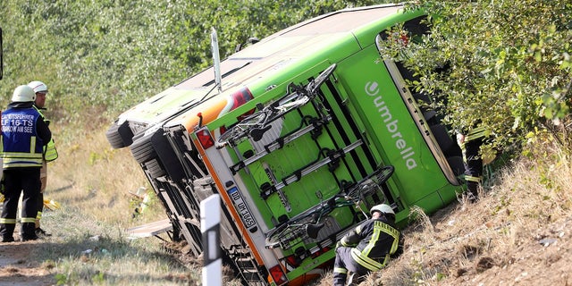 A bus sits beside the Autobahn A 19 in Linstow near Rostock, northern Germany, Friday, Aug. 17, 2018, after it was driven into a ditch and turned over.