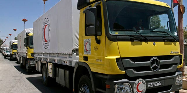 July 14, 2014: Syrian Red Crescent trucks loaded with food parcels under the supervision of the U.N., the Red Crescent and in coordination with the Syrian government, prepare to distribute aid to tens of thousands of besieged Syrians inside the rebel-held Damascus suburb of Moadamiyeh, Syria.