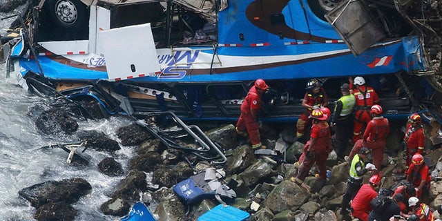 In this photo provided by the government news agency Andina, firemen recover bodies from a bus that fell off a cliff after it was hit by a tractor-trailer rig in Pasamayo, Peru, on Tuesday. Peruvian officials said at least 48 people died, and that there were more than 50 people on the bus.