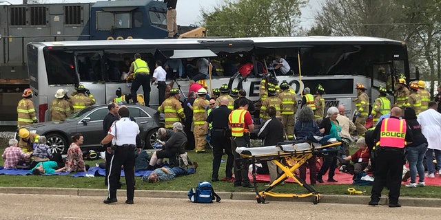 Biloxi, Miss., firefighters help passengers of a charter bus out of the damaged vehicle after the bus collided with a train Tuesday afternoon, March 7, 2017. (John Fitzhugh/The Sun Herald, via AP)