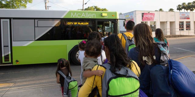 Immigrant families board a bus headed to the downtown bus station in McAllen, Texas on April 30, 2015.
