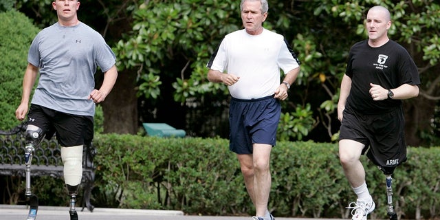 U.S. President George W. Bush (C) jogs with U.S. Army Sgt. Neil Duncan (L) and U.S. Army Specialist Max Ramsey at the White House in Washington July 25, 2007. Duncan lost both legs in Afghanistan in December 2005 and Ramsey lost his left leg in Iraq in March 2006. REUTERS/Larry Downing (UNITED STATES) - RTR1S8XP