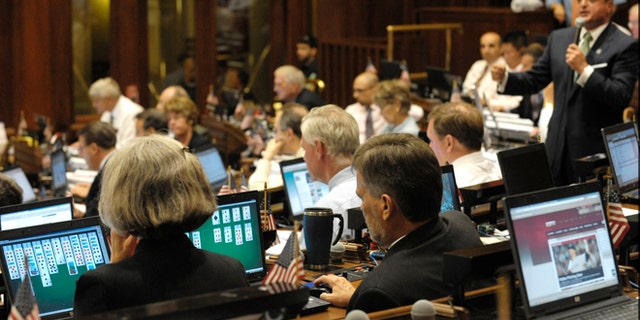 State legislators play solitaire and surf the internet on laptop computers while House Minority Leader Lawrence F. Cafero Jr. speaks prior to a vote on the state budget in 2009.