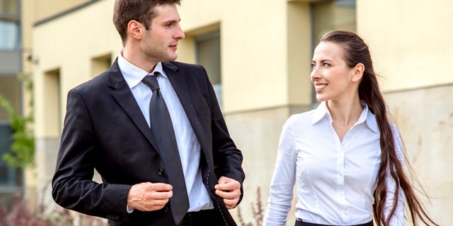 Young business couple walking outdoor near the office building
