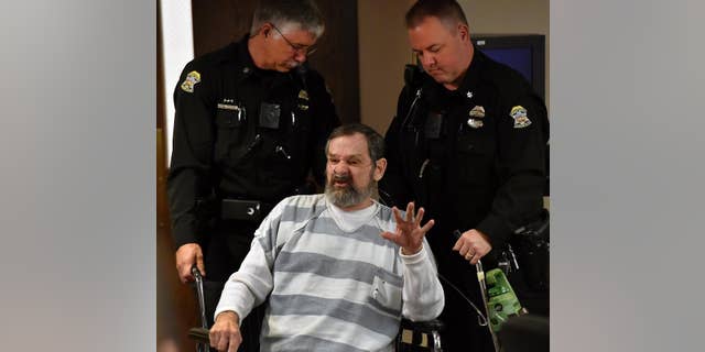 FILE - In this April 2014 file photo, Frazier Glenn Miller is wheeled out of a Johnson County, Kan., courtroom. A judge ruled Tuesday, March 2, 2015 that Miller, 74, will go on trial for the 2014 deaths of Dr. William Lewis Corporon, 69, and his grandson, Reat Griffin Underwood, 14, at the Jewish Community Center of Greater Kansas City in Overland Park and Terri LaManno, 53, at a nearby Jewish retirement home. (AP Photo/The Kansas City Star, Rich Sugg, Pool, File)