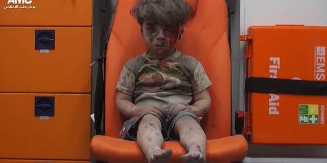 In this Aug. 17, 2016 file frame grab taken from video provided by the Syrian anti-government activist group Aleppo Media Center (AMC), 5-year-old Omran Daqneesh sits in an ambulance after being pulled out of a building hit by an airstrike in Aleppo, Syria.