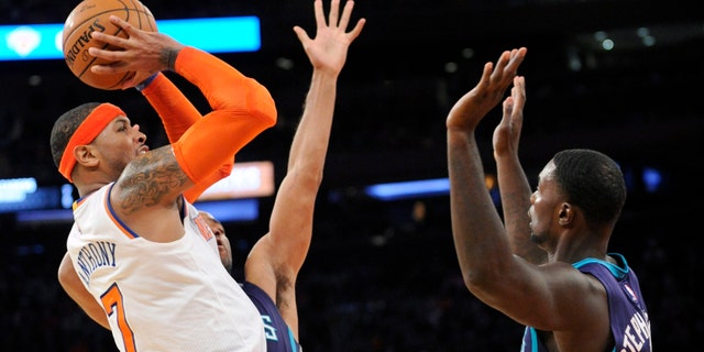 New York Knicks' Carmelo Anthony (7) attempts a shot as he is guarded by Charlotte Hornets' Gerald Henderson and Lance Stephenson, right, during the fourth quarter of an NBA basketball game Sunday, Nov. 2, 2014, at Madison Square Garden in New York. The Knicks won 96-93. (AP Photo/Bill Kostroun)