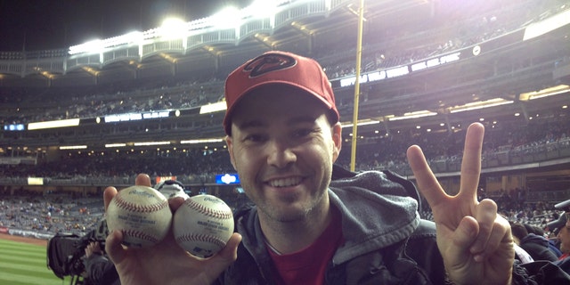 Zack Hample, a 35-year-old New Yorker holds the two balls he caught in the right-field seats Thursday April 18, 2013, during the Yankees-Diamondbacks game.