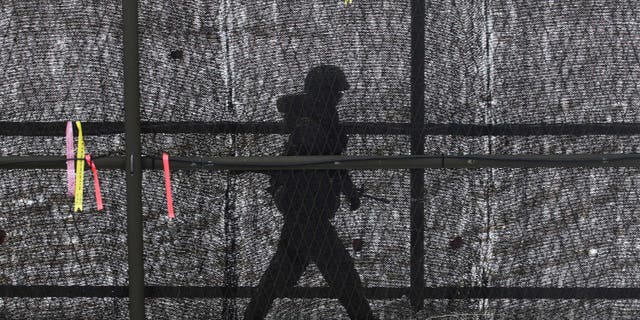 A South Korean army soldier patrols inside the barbed-wire fence at Imjingak in Paju near the demilitarized zone (DMZ) of Panmunjom, South Korea, Sunday, Feb. 17, 2013. North Korea is upgrading one of its two major missile launch sites, apparently to handle much bigger rockets, and some design features suggest it is getting help from Iran, a U.S. research institute said last Thursday. (AP Photo/Ahn Young-joon)