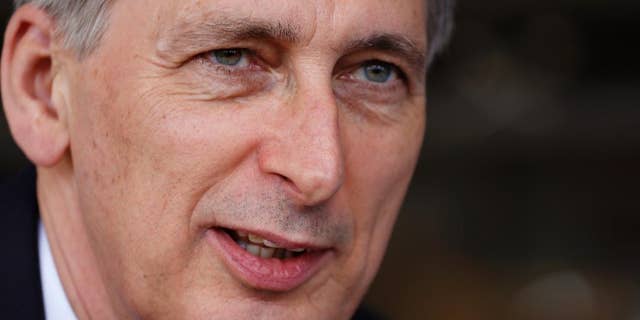 FILE - In a Thursday, Dec. 8, 2016 file photo, British Finance Minister Philip Hammond speaks to South African businessmen during a visit to a British funded project in Cape Town, South Africa. Hammond said Sunday, Jan. 15 that the UK will take whatever steps necessary to stay competitive in the global economy, if the country is shut out of the European Union market. (AP Photo/Schalk van Zuydam, File)