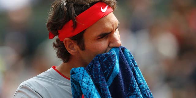 Switzerland's Roger Federer wipes his face during the first round match of the French Open tennis tournament against Slovakia's Lukas Lacko at the Roland Garros stadium, in Paris, France, Sunday, May 25, 2014. (AP Photo/Darko Vojinovic)