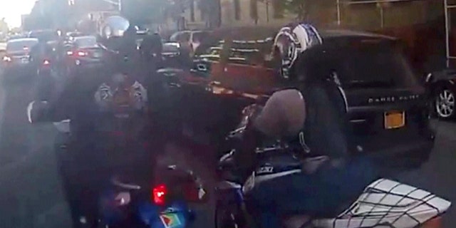 Motorcyclists ride alongside Alexian Lien's sport utility vehicle, Sunday, Sept. 29, 2013, in New York.