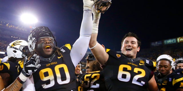 Arizona State's Will Sutton (90) and Evan Finkenberg (62) hold the Territorial Cup in celebration after an NCAA college football game against Arizona Saturday, Nov. 30, 2013, in Tempe, Ariz. Arizona State defeated Arizona 58-21. (AP Photo/Ross D. Franklin)