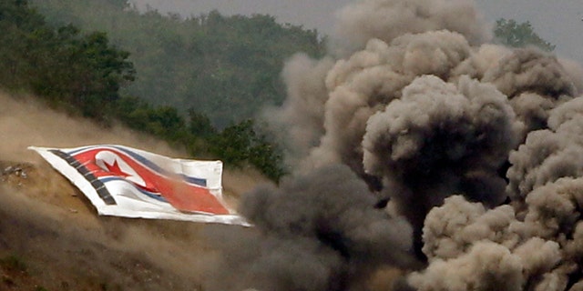 June 19, 2012: In this photo, smoke rises from explosions near the North Korean flag during South Korea-U.S. joint military live-fire drills at Seungjin Fire Training Field in Pocheon, South Korea, near the border with North Korea.