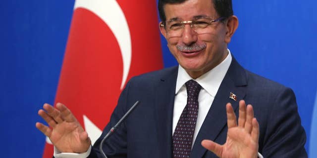 Turkish Prime Minister and leader of Justice and Development Party Ahmet Davutoglu speaks to the media after a meeting with Kemal Kilicdaroglu, the leader of the main opposition Republican People's Party, CHP, in Ankara, Turkey, Monday, July 13. 2015. Davutoglu has begun a first round of talks on forming a coalition government by meeting officials of Turkey’s secularist party, CHP, his ruling Islamic-rooted party’s arch-foe. Davutoglu met with Kilicdaroglu on Monday, a month after Turkey’s June 7 election left his party short of a majority, forcing it to seek a coalition alliance.(AP Photo/Burhan Ozbilici)