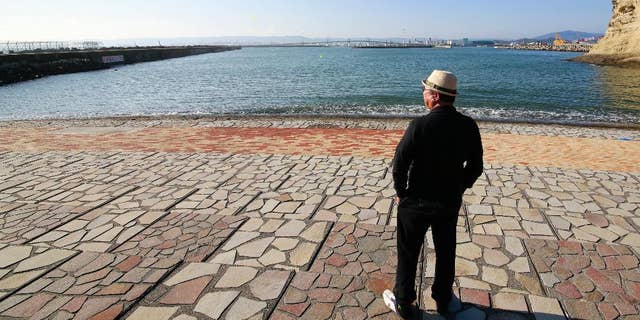 A man looks at sea after tsunami warning was lifted at Onahama coastal region in Iwaki, Fukushima prefecture, northeastern Japan, Tuesday, Nov. 22, 2016. Coastal residents fled to higher ground as a powerful earthquake sent a series of moderate tsunamis toward Japan's northeastern shore Tuesday and fueled concerns about the Fukushima nuclear power plant destroyed by a much larger tsunami five years ago. (AP Photo/Shizuo Kambayashi)