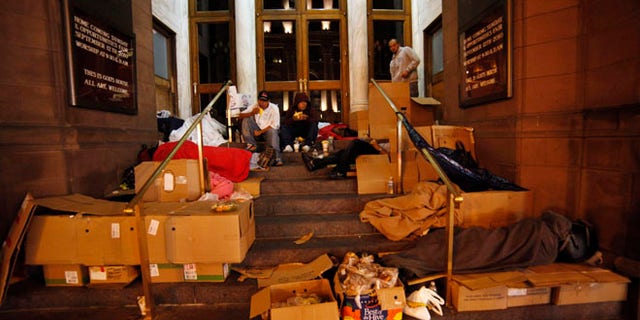 Homeless people eat food donated by a charity organization called HomelessBus.org.