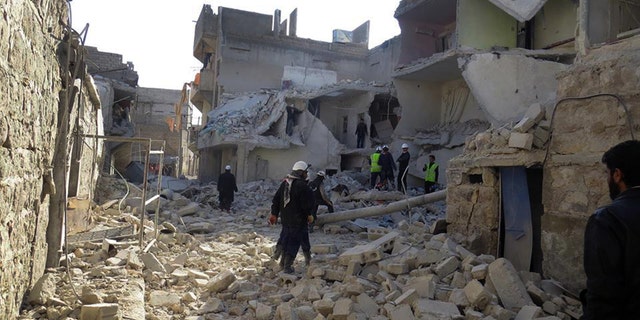 This citizen journalism image provided by Aleppo Media Center (AMC), an anti-Bashar Assad activist group which has been authenticated based on its contents and other AP reporting, shows Syrian rescue workers check the rubble of a destroyed building which was attacked by Syrian forces warplanes, in Aleppo, Syria, Tuesday, Jan. 21, 2014. (AP Photo/Aleppo Media Center, AMC)