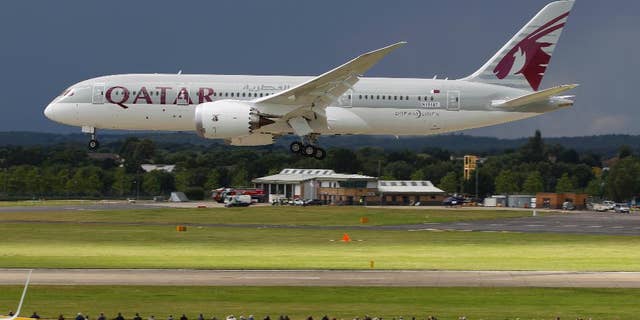 FILE- in this file photo dated Wednesday, July 11, 2012, onlookers watch as a Qatar Airways Boeing 787 Dreamliner lands during an aerial display at the Farnborough International Airshow, in Farnborough, England.  The state-owned Commercial Aircraft Corp. of China, known as Comac, announced plans this week at Farnborough airshow 2016, for a wide-body aircraft to be built with state-owned Russian maker United Aircraft Corporation, striking at the heart of the market leaders Airbus and Boeing. (AP Photo/Lefteris Pitarakis, FILE)
