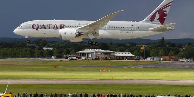 FILE- in this file photo dated Wednesday, July 11, 2012, onlookers watch as a Qatar Airways Boeing 787 Dreamliner lands during an aerial display at the Farnborough International Airshow, in Farnborough, England. The state-owned Commercial Aircraft Corp. of China, known as Comac, announced plans this week at Farnborough airshow 2016, for a wide-body aircraft to be built with state-owned Russian maker United Aircraft Corporation, striking at the heart of the market leaders Airbus and Boeing. (AP Photo/Lefteris Pitarakis, FILE)